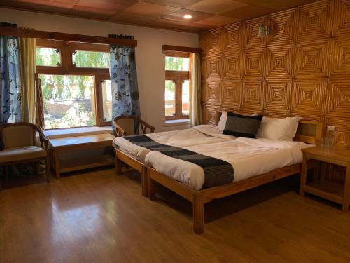 a bedroom with a large bed with a wooden wall at Sangto Green Guest House in Leh