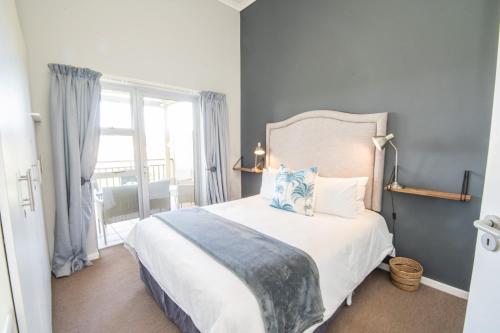 Un dormitorio con una cama grande y una ventana en Goose Valley Golf Estate Unit J6 en Plettenberg Bay