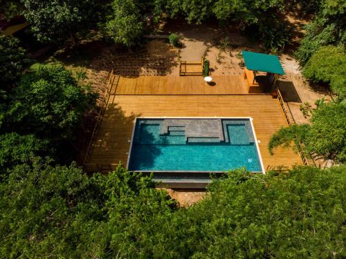 a pool with a tennis court and a pool table at Sweet Songs Jungle Lodge in San Ignacio