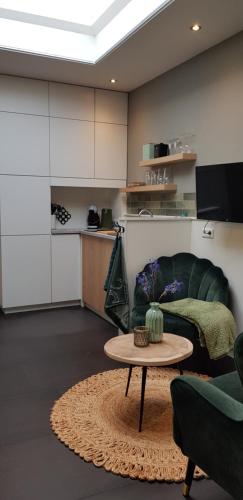 uma sala de estar com um sofá e uma mesa em Studio Klein Schoorl em Schoorl