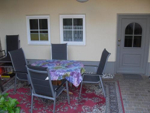 een tafel en stoelen met een tafel en een deur bij Wohnen Im Topf in Quedlinburg