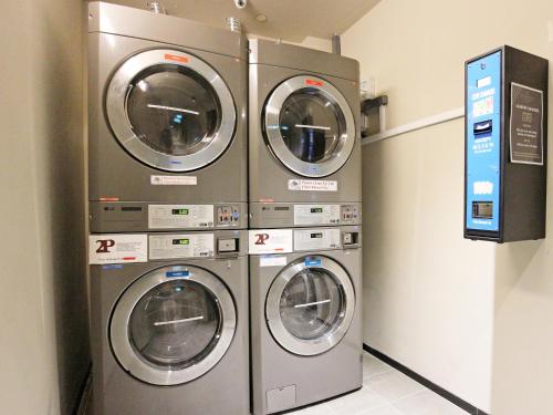 three washing machines are in a laundry room at ST Signature Jalan Besar, DAYUSE, 5 Hours, 5PM-10PM in Singapore