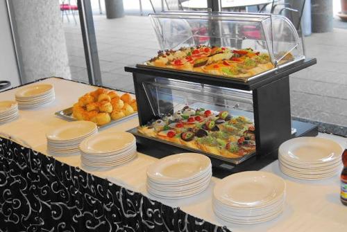 een buffet met borden en eten op tafel bij Gokart Hotel in Kecskemét