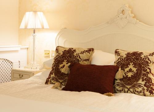 Una cama blanca con dos almohadas encima. en The Old Kiln House, en Shipston on Stour