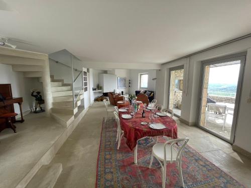 ein Esszimmer mit einem Tisch, Stühlen und einer Treppe in der Unterkunft Maison a Gordes Centre 200m2 Terrasse panoramique in Gordes