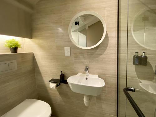 a bathroom with a sink and a toilet and a mirror at ST Signature Jalan Besar, SHORT OVERNIGHT, 13 Hours, 6PM-7AM in Singapore