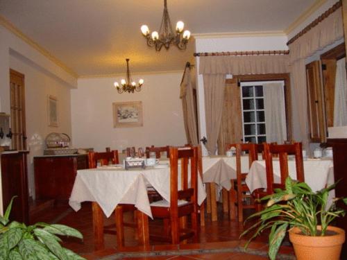 una sala da pranzo con tavolo, sedie e lampadario pendente di Descanso Serrano a Manteigas