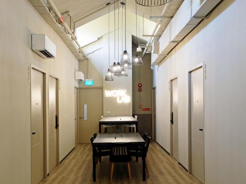 a hallway with a table and chairs in a room at ST Signature Jalan Besar, DAYUSE, 7 Hours, 9AM-4PM in Singapore