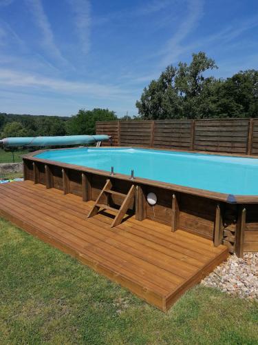 a large swimming pool with a wooden deck at Hôtes de l'Isle in Saint-Médard-de-Mussidan