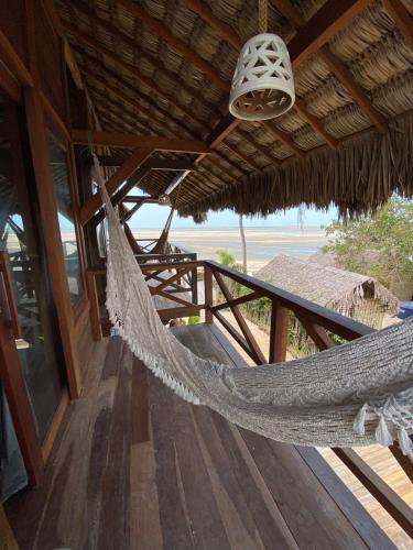 a hammock on a porch of a building at Pousada Portal do Kite in Tatajuba