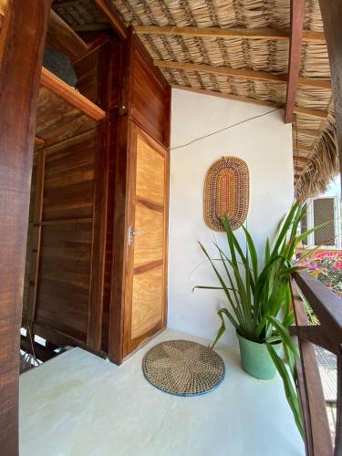 a small room with a door and a plant at Pousada Portal do Kite in Tatajuba