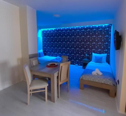 a bedroom with a bed and a table and chairs at Apartmani CENTAR- Smederevo in Smederevo