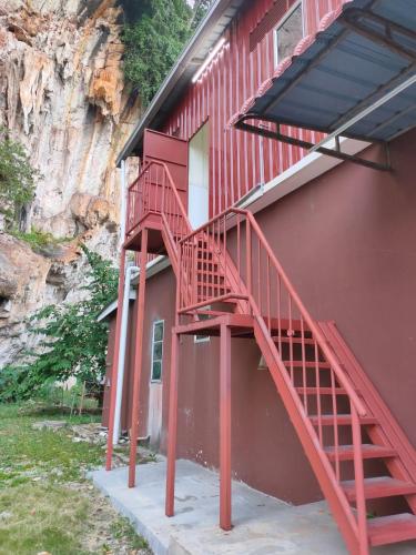 una escalera roja en el lateral de un edificio rojo en Homestay Teduhan Gunung, Gopeng en Gopeng