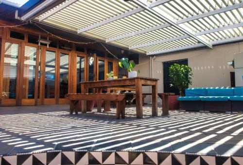 a patio with a wooden table and a bench at Villa Viva Cape Town in Cape Town