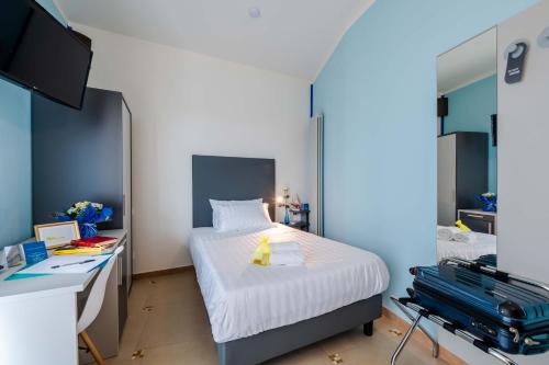 a bedroom with a bed and a desk with a suitcase at AppartaHotel in Beinasco