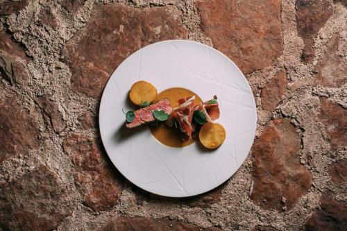 a white plate with food on top of a table at Montebelo Vista Alegre Ílhavo Hotel in Ílhavo