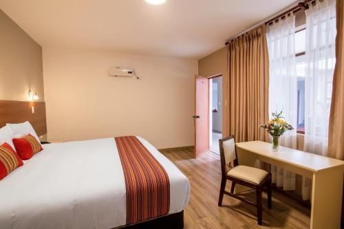 a hotel room with a bed and a desk at Hotel San Pedro Plaza in Cusco