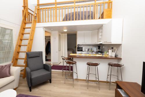 a living room with a kitchen and a loft bed at Koivukuja Apartment in Vuokatti