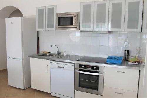 a white kitchen with a sink and a refrigerator at African Sunset in Sal Rei