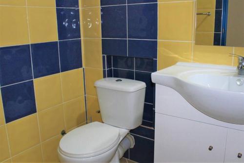 a bathroom with a white toilet and a sink at African Sunset in Sal Rei