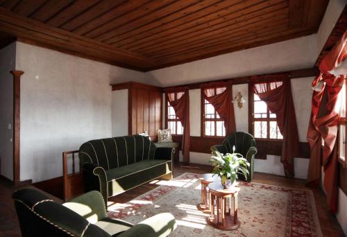 a living room with green chairs and a table at Gulevi Safranbolu in Safranbolu