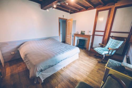 a bedroom with a bed and a chair and a fireplace at Fermette les Ormes, 8 personnes, Merlimont village in Merlimont