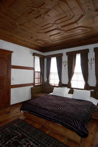a bedroom with a large bed with a wooden ceiling at Gulevi Safranbolu in Safranbolu