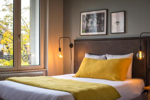 Hello Colmar, Duplex Cathedrale, historic center في كولمار: غرفة نوم بسرير وبطانية صفراء ونافذة