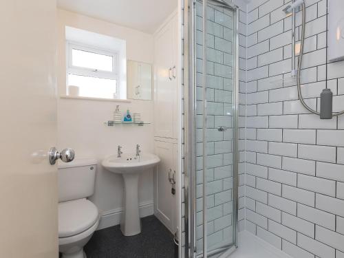 een witte badkamer met een toilet en een wastafel bij Trengoff in St Ives