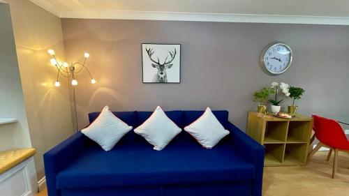 a blue couch with pillows in a living room at RiverView 1 Bed Apartment with Parking by CozyNest in Reading