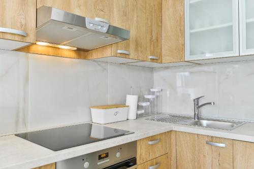 a kitchen with wooden cabinets and a sink at Cascada villas by Adex Travel in Starigrad-Paklenica