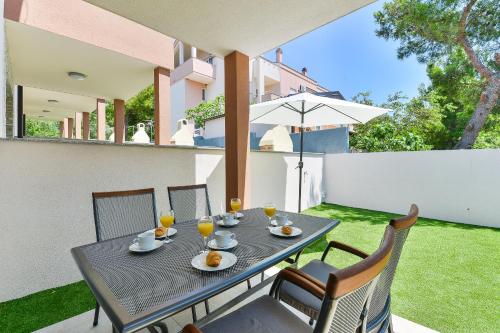 a table with glasses of orange juice sitting on a patio at Cascada villas by Adex Travel in Starigrad-Paklenica