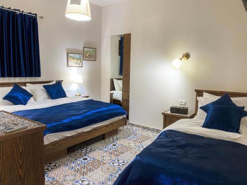 a bedroom with two beds with blue sheets at Abu Hanna Boutique by Ahlan Hospitality in Nazareth
