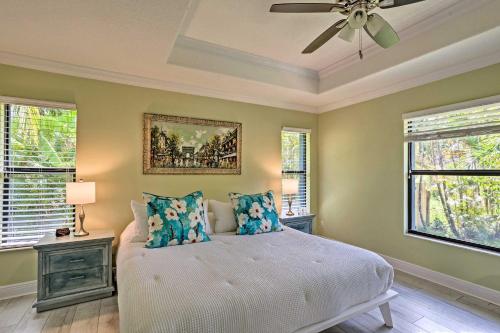 a bedroom with a bed with a ceiling fan and windows at Tropical Cottage with Patio, Gas Grill and Fire Pit! in Jupiter