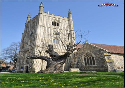 a statue of a tree in front of a church at RiverView 1 Bed Apartment with Parking by CozyNest in Reading