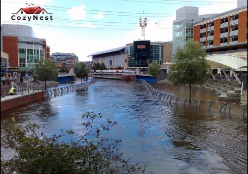 a river in the middle of a city with buildings at RiverView 1 Bed Apartment with Parking by CozyNest in Reading