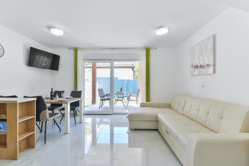 a living room with a white couch and a table at Cascada villas by Adex Travel in Starigrad-Paklenica