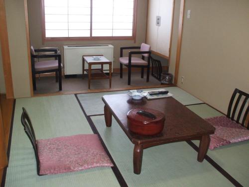 a living room with a table and chairs at Annex Fujiya Ryokan in Kaminoyama