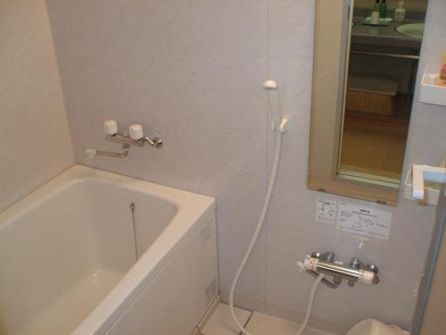 a bathroom with a bath tub and a sink at Annex Fujiya Ryokan in Kaminoyama