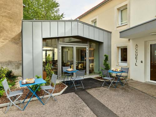 a patio with tables and chairs in front of a building at Hôtel REVOTEL Nancy Centre Gare et Congrès in Nancy