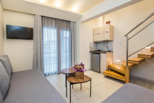 a living room with a couch and a table with flowers at Estian Deluxe in Limenaria