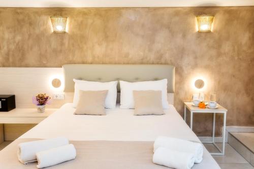 a bedroom with a large white bed with two pillows at Estian Deluxe in Limenaria