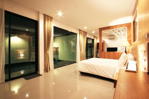 a bedroom with a bed and a large window at The Vista Pool Villa in Kanchanaburi