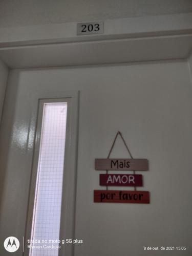 a sign hanging on a wall next to a window at AP Praia - Vog 2 quartos com AR e D'Ouro Park-Rua dos Tangarás, 20 todo climatizado in Ilhéus