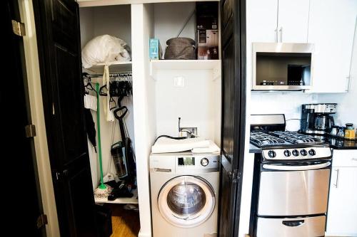 a kitchen with a washing machine and a stove at NEWLY RENOVATED HEART OF LOWER EAST SIDE 2BR 1BA, 5 MIN WALK TO SOHO, 1 BLOCK TO WHOLE FOODS, WASHER DRYER! in New York