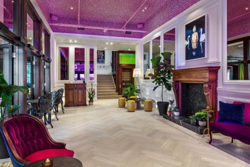 a living room with a fireplace and purple ceilings at Gladstone House in Toronto