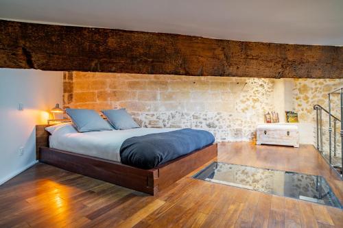 - une chambre avec un grand lit et un mur en briques dans l'établissement L'Olivier Loft HH Centre Corum - Netflix & Prime Video 4k, à Montpellier