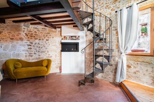 uma sala de estar com um sofá amarelo e uma escada em espiral em L'Olivier Loft HH Centre Corum - Netflix & Prime Video 4k em Montpellier