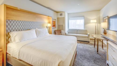 a hotel room with a large bed and a couch at Holiday Inn & Suites Bellingham by IHG in Bellingham