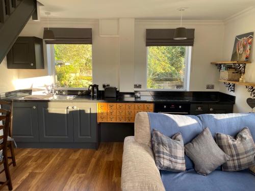 a living room with a couch and a kitchen at Holme Valley Vista, Holmfirth in Holmfirth